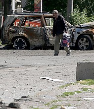 A man walks past the wreckage of a car in Lysychansk on June 21, as Ukraine says Russian shelling has caused "catastrophic destruction" in the eastern industrial city.
Mandatory Credit:	ANATOLII STEPANOV/AFP/AFP via Getty Images