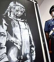 A policeman stands guard near a piece of art attributed to Banksy, that was stolen at the Bataclan in Paris in 2019.
Mandatory Credit:	FILIPPO MONTEFORTE/AFP via Getty Images
