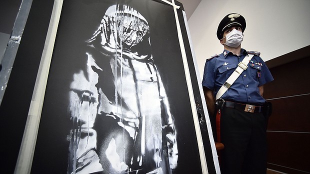 A policeman stands guard near a piece of art attributed to Banksy, that was stolen at the Bataclan in Paris in 2019.
Mandatory Credit:	FILIPPO MONTEFORTE/AFP via Getty Images