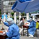 Health workers take swab samples to be tested for Covid-19 at a makeshift testing site along a street in Beijing on May 11.
Mandatory Credit:	Jade Gao/AFP/Getty Images