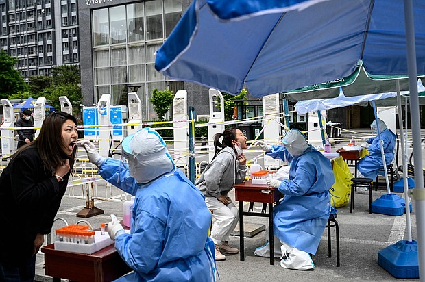 Health workers take swab samples to be tested for Covid-19 at a makeshift testing site along a street in Beijing on May 11.
Mandatory Credit: Jade Gao/AFP/Getty Images