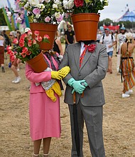 A couple dressed as flower pots walk around the site during day two of Glastonbury.
Mandatory Credit:	Dave J Hogan/Getty Images
