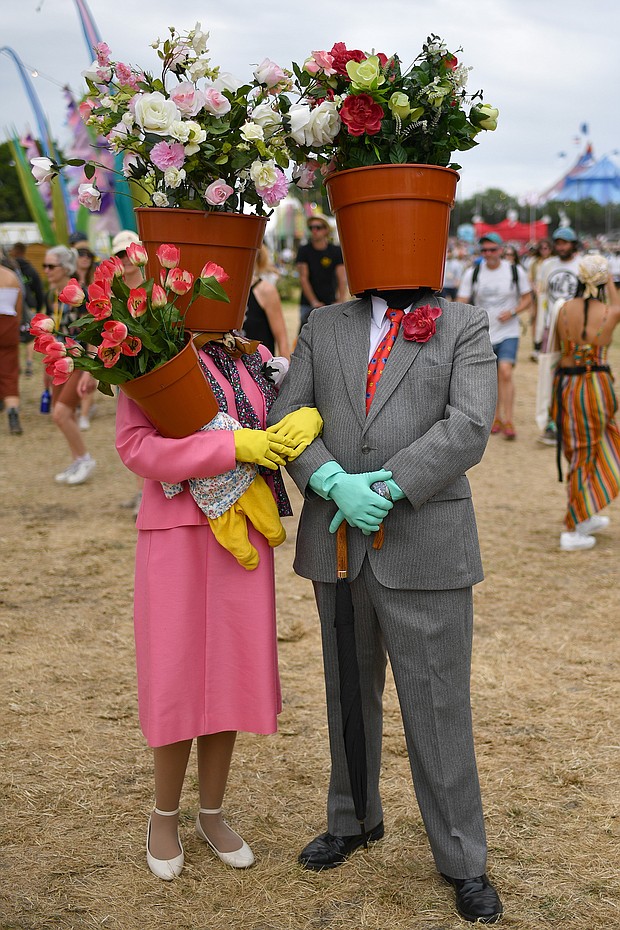 A couple dressed as flower pots walk around the site during day two of Glastonbury.
Mandatory Credit:	Dave J Hogan/Getty Images