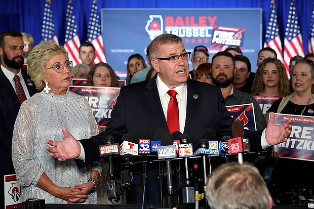 Republican gubernatorial primary candidate Darren Bailey, center, stands with his wife, Cindy Stortzum, and responds to reporters' questions after winning the Republican gubernatorial primary on  June 28, in Effingham, Ill.
Mandatory Credit:	Charles Rex Arbogast/AP