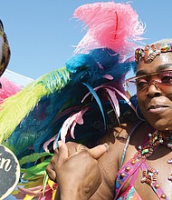 Marie Dumont-Pierce of Chesterfield, left, feels the music and dances with Nissa Edmonds of Norfolk, who is a part of a group called, Natural vyb Mas Carnival Band. Ms. Dumont- Pierce is in her carnival costume during the 2nd annual Caribbean American Heritage Festival June 25 at Henrico County’s Dorey Park in Varina. The free event attracted long lines of people waiting to enter the park for the food trucks, vendors and live music.