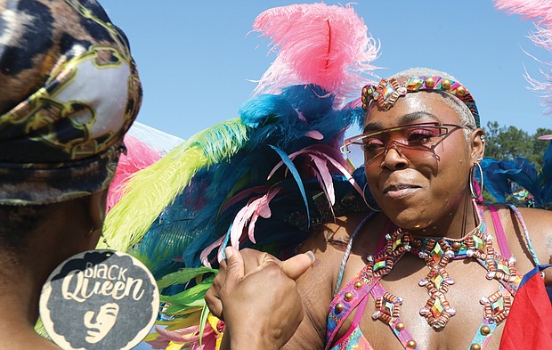 Marie Dumont-Pierce of Chesterfield, left, feels the music and dances with Nissa Edmonds of Norfolk, who is a part of a group called, Natural vyb Mas Carnival Band. Ms. Dumont- Pierce is in her carnival costume during the 2nd annual Caribbean American Heritage Festival June 25 at Henrico County’s Dorey Park in Varina. The free event attracted long lines of people waiting to enter the park for the food trucks, vendors and live music.