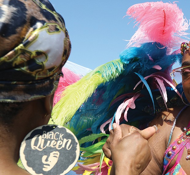 Marie Dumont-Pierce of Chesterfield, left, feels the music and dances with Nissa Edmonds of Norfolk, who is a part of a group called, Natural vyb Mas Carnival Band. Ms. Dumont- Pierce is in her carnival costume during the 2nd annual Caribbean American Heritage Festival June 25 at Henrico County’s Dorey Park in Varina. The free event attracted long lines of people waiting to enter the park for the food trucks, vendors and live music.