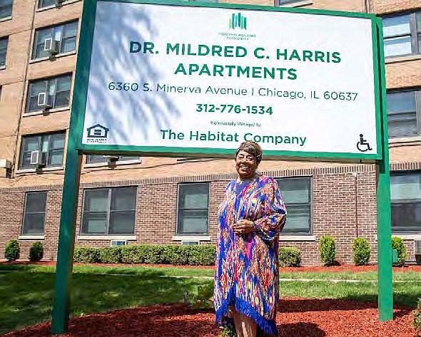 CHA Commissioner Dr. Mildred C. Harris stands in front of the new sign at the South Side Apartments named for her at a dedication ceremony Wednesday, June 29, 2022.