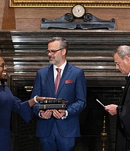 Judge Ketanji Brown Jackson takes her constitutional oath of office as an associate justice of the U.S. Supreme Court administered by Chief Justice John Roberts as Judge Jackson’s husband Patrick Jackson holds the Bible in a handout image provided by the U.S. Supreme Court from ceremonies held June 30 at the Supreme Court building in Washington.