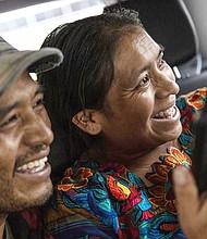 Mynor Cardona and Ufemia Tomas, parents of Yenifer Yulisa Cardona Tomás, smile as they talk with her.