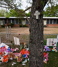 A cross hangs on a tree at Robb Elementary School on June 3, 2022, in Uvalde, Texas, where a memorial has been created to honor the victims killed in the recent school shooting. Two teachers and 19 students were killed.
Mandatory Credit: Eric Gay/AP