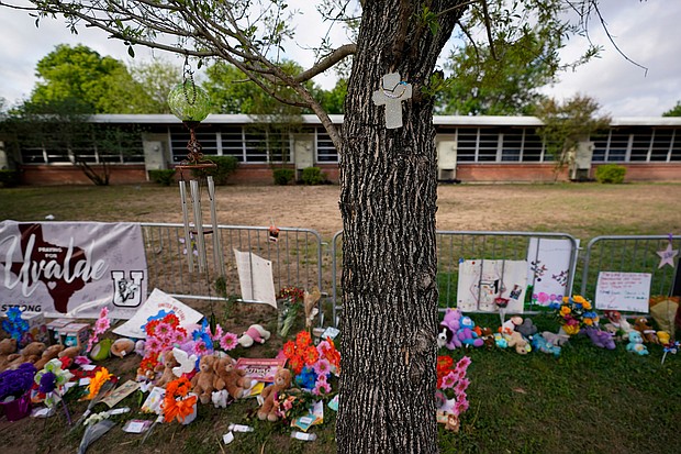 A cross hangs on a tree at Robb Elementary School on June 3, 2022, in Uvalde, Texas, where a memorial has been created to honor the victims killed in the recent school shooting. Two teachers and 19 students were killed.
Mandatory Credit:	Eric Gay/AP