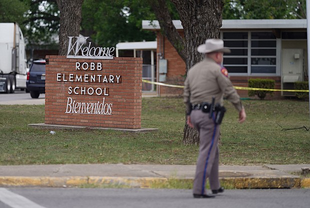 An officer walks outside of Robb Elementary School in Uvalde, Texas, on May 24.
Mandatory Credit:	Allison Dinner/AFP/Getty Images