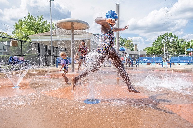 Skylar Bauder, 9, cools off on the splash pad at the Battery Park Community Center Pool in North Side.