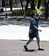 A pedestrian walks with a bag covering her face to block the sun during a heatwave in Houston, Texas.
Mandatory Credit:	Mark Felix/Bloomberg/Getty Images