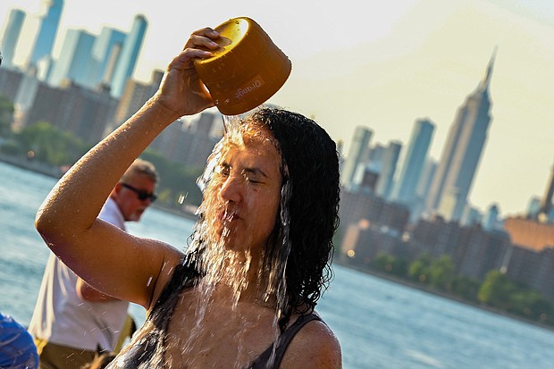 A woman pours water on her face in New York City as temperatures soared into the upper 90s on Sunday.
Mandatory Credit:	Alexi Rosenfeld/Getty Images
