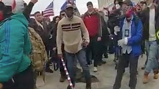 A frame taken from the body worn camera of a of MPD Officer shows Mark Ponder armed with a long pole with red, white, and blue stripes.
Mandatory Credit:	Dept. of Justice