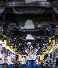 Employees wearing masks work on a car assembly line at the SAIC General Motors Co.
Mandatory Credit:	Ren Yong/SOPA Images/LightRocket/Getty Images