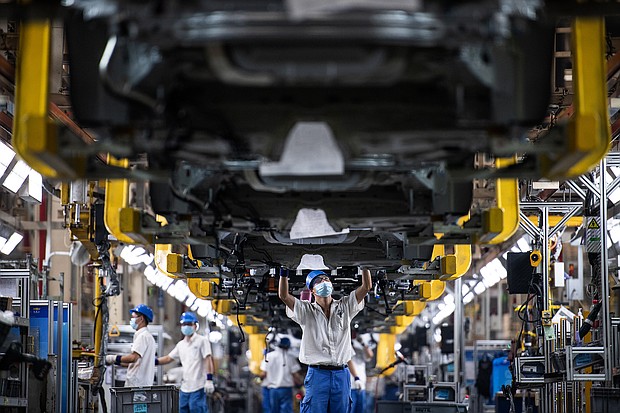 Employees wearing masks work on a car assembly line at the SAIC General Motors Co.
Mandatory Credit:	Ren Yong/SOPA Images/LightRocket/Getty Images