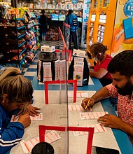 Nancy Linares, left, and Prince Joseph Israel fill out Mega Millions playslips at Blue Bird Liquor in Hawthorne, California, Tuesday.
Mandatory Credit:	Jae C. Hong/AP