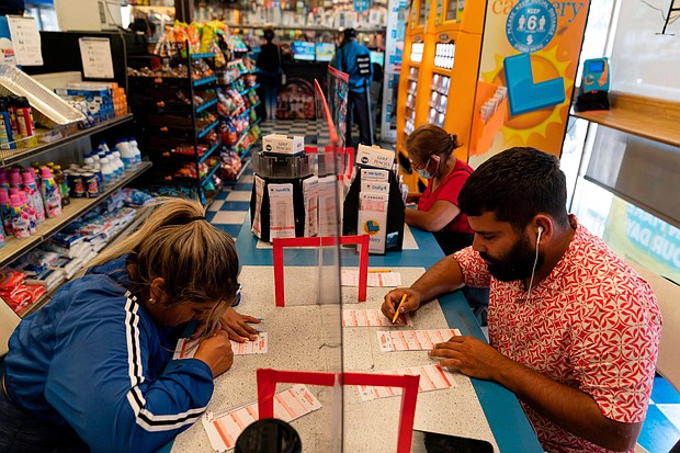 Nancy Linares, left, and Prince Joseph Israel fill out Mega Millions playslips at Blue Bird Liquor in Hawthorne, California, Tuesday.
Mandatory Credit:	Jae C. Hong/AP