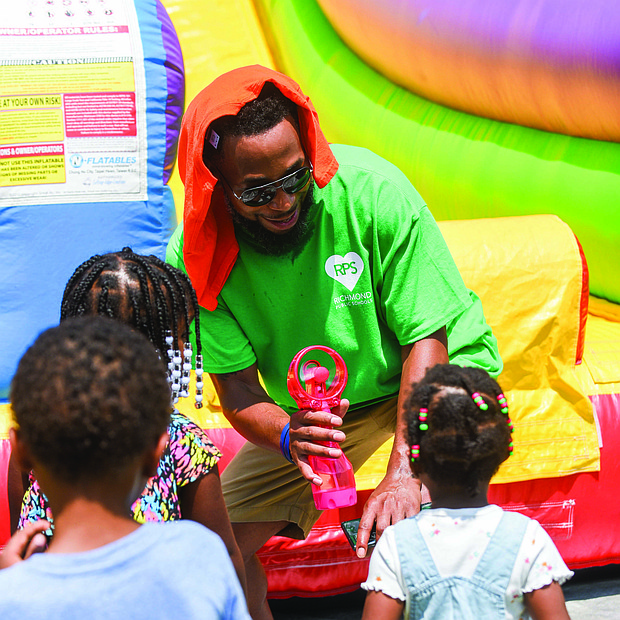 Brandon Lee gives a cool blast to children who lined up to enjoy the inflatable slide during the RPS Summer Fest at George Wythe High School on July 23. Families and students attending the event learned what to expect during the 2022-23 school year, and also met teachers, staff and school administrators. Adding to the festivities were cool food and bever- age treats, art stations, the RPS Lit Limo and loads of laughter.