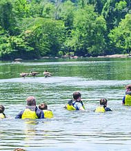A James River Park System official helps a group navigate the James River on River Safety Day on July 23. The event is designed to help river visitors feel comfortable in the water as they learn critical safety measures.