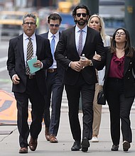 Lawrence Rudolph's defense investigator, left, heads into federal court in Denver along with the dentist's children. Rudolph, a dentist and big-game hunter, was found guilty of murder in the shooting death of his wife on an African safari on August 2.
Mandatory Credit:	David Zalubowski/AP