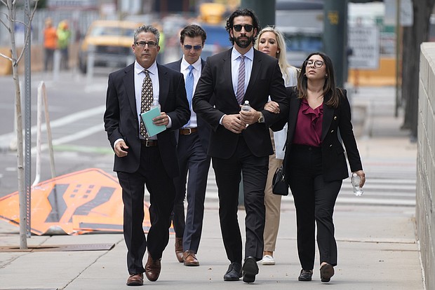 Lawrence Rudolph's defense investigator, left, heads into federal court in Denver along with the dentist's children. Rudolph, a dentist and big-game hunter, was found guilty of murder in the shooting death of his wife on an African safari on August 2.
Mandatory Credit:	David Zalubowski/AP