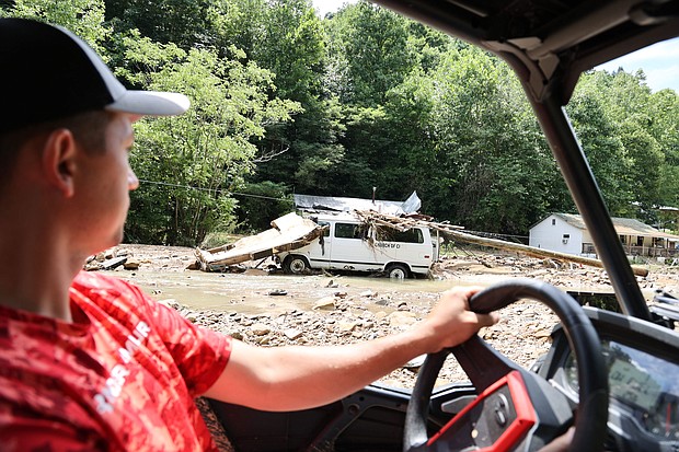 Resident Louis Turner carries water to friends and family along flood-ravaged Bowling Creek, Kentucky.
Mandatory Credit:	Chris Kenning/USA Today Network/Reuters