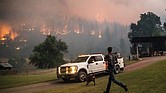 A man runs to a truck as a wildfire called the McKinney fire burns last week in Klamath National Forest, Calif.
