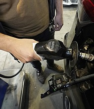 Predatory lenders are reportedly making money off rising gas and food prices, and pictured a customer pumps gasoline into his car at a Sam's Club fuel island in Gulfport, Miss., Feb. 19.
Mandatory Credit:	Rogelio V. Solis/AP