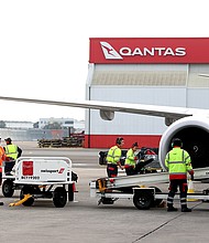 Members of the ground crew work next to an aircraft operated by Qantas Airways Ltd. at Sydney Airport in Sydney, Australia, on June 23, 2021.    Qantas has asked its senior executives to help out as airport baggage handlers as it struggles to manage a staff shortage.
Mandatory Credit:	Brendon Thorne/Bloomberg/Getty Images/FILE