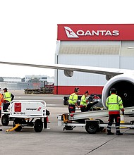 Members of the ground crew work next to an aircraft operated by Qantas Airways Ltd. at Sydney Airport in Sydney, Australia, on June 23, 2021. Qantas has asked its senior executives to help out as airport baggage handlers as it struggles to manage a staff shortage.
Mandatory Credit: Brendon Thorne/Bloomberg/Getty Images/FILE