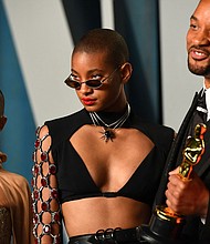 Willow Smith (center) is pictured with Will Smith and Jada Pinkett Smith. Willow Smith says she was not fazed by the media firestorm that broke out after her father, Will Smith, slapped Chris Rock at the 2022 Academy Awards, because she sees her "whole family as being human."
Mandatory Credit:	Patrick T. Fallon/AFP/Getty Images