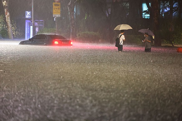 At least eight people were killed in Seoul on Monday after record downpours flooded homes, roads and subway stations in …