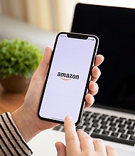 More than a dozen companies are developing a single standard for detecting cyberattacks faster. A woman holding an iPhone X with Amazon on the screen is pictured here in Russia in September 2018.
Mandatory Credit:	Adobe Stock