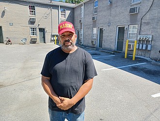 Bobby L. McIntosh stands in the courtyard of a 28-unit complex at 401 E. Brookland Park Blvd. that he manages.