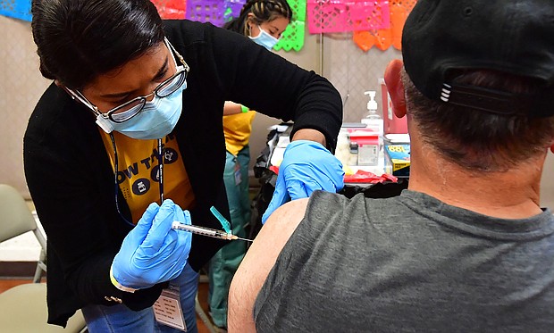 Registered Nurse Mariam Salaam administers the Pfizer booster shot at a Covid vaccination and testing site decorated for Cinco de Mayo at Ted Watkins Park in Los Angeles on May 5.
Mandatory Credit:	Frederic J. Brown/AFP/Getty Images