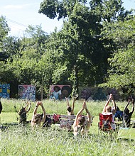 Jonathan Christopher Miles, a Richmond yoga trainer, leads “Yoga for the People,” a community yoga class at Sankofa Community Orchard at 309 Covington Road on Aug. 13. He was accompanied by Shanna Latia, who provided sound bowl healing during the session.