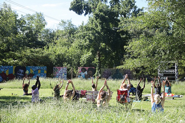 Jonathan Christopher Miles, a Richmond yoga trainer, leads “Yoga for the People,” a community yoga class at Sankofa Community Orchard at 309 Covington Road on Aug. 13. He was accompanied by Shanna Latia, who provided sound bowl healing during the session.