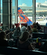 Passengers wait in a terminal at Dallas-Fort Worth International Airport (DFW) on Aug. 11, a day after unexpected thunderstorms hit the region.
Mandatory Credit:	Kirby Lee/AP