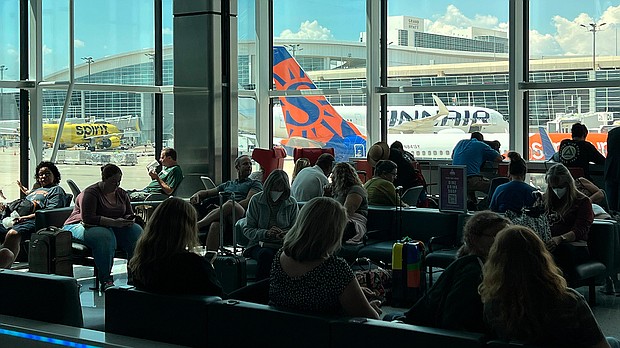Passengers wait in a terminal at Dallas-Fort Worth International Airport (DFW) on Aug. 11, a day after unexpected thunderstorms hit the region.
Mandatory Credit:	Kirby Lee/AP