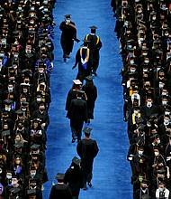 Graduates file down the aisle during a commencement ceremony at the University of Massachusetts in August 2021. US Education Secretary Miguel Cardona said on August 21 that an announcement on student loans is expected in the "next week or so."
Mandatory Credit:	Craig F. Walker/The Boston Globe/Getty Images