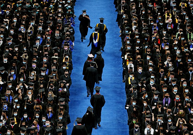 Graduates file down the aisle during a commencement ceremony at the University of Massachusetts in August 2021. US Education Secretary Miguel Cardona said on August 21 that an announcement on student loans is expected in the "next week or so."
Mandatory Credit:	Craig F. Walker/The Boston Globe/Getty Images
