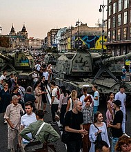 People gather in Kyiv to look at destroyed Russian military equipment.