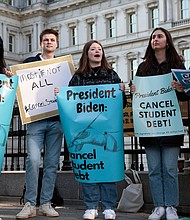 Activists hold signs as they attend a Student Loan Forgiveness rally near the White House on April 27. The White House is leaning toward canceling $10,000 in student loan debt for borrowers who make less than $125,000.
Mandatory Credit:	Anna Moneymaker/Getty Images