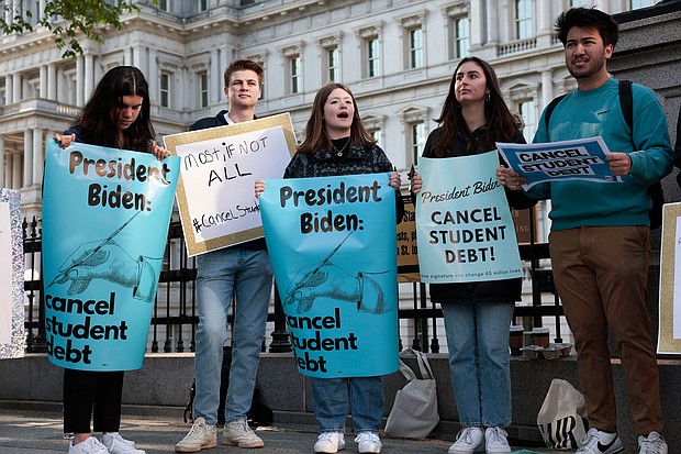 Activists hold signs as they attend a Student Loan Forgiveness rally near the White House on April 27. The White House is leaning toward canceling $10,000 in student loan debt for borrowers who make less than $125,000.
Mandatory Credit:	Anna Moneymaker/Getty Images