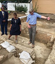 Rev. Reginald F. Davis, from left, pastor of First Baptist Church, Connie Matthews Harshaw, a member of First Baptist and president of the Let Freedom Ring Foundation that preserves First Baptist’s history, and Jack Gary, Colonial Williamsburg’s director of archaeology, stand at the brick-and-mortar foundation of one the oldest Black churches in the U.S. on Oct. 6, 2021, in Williamsburg. Archaeologists in Virginia began excavating three suspected graves at the site on Monday, July 18, 2022, commencing a monthslong effort to learn who was buried there and how they lived.