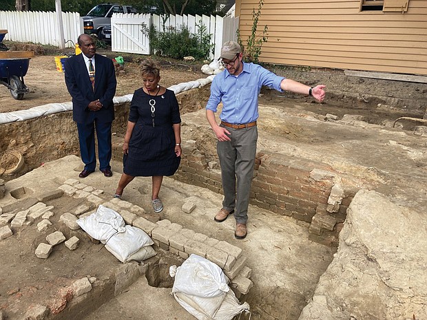 Rev. Reginald F. Davis, from left, pastor of First Baptist Church, Connie Matthews Harshaw, a member of First Baptist and president of the Let Freedom Ring Foundation that preserves First Baptist’s history, and Jack Gary, Colonial Williamsburg’s director of archaeology, stand at the brick-and-mortar foundation of one the oldest Black churches in the U.S. on Oct. 6, 2021, in Williamsburg. Archaeologists in Virginia began excavating three suspected graves at the site on Monday, July 18, 2022, commencing a monthslong effort to learn who was buried there and how they lived.